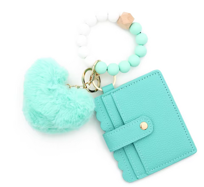 Turquoise keychain with pom-pom and cardholder on a white background